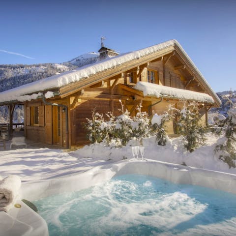 Soak in the hot tub as snow falls around you