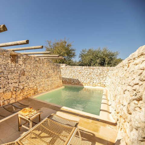 Relax on a lounger by the private swimming pool