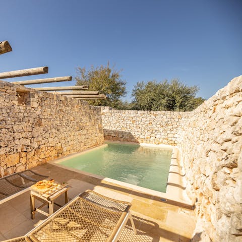 Relax on a lounger by the private swimming pool