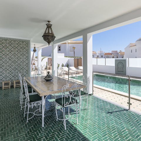 Dine alfresco on the outdoor patio that mirrors the pool