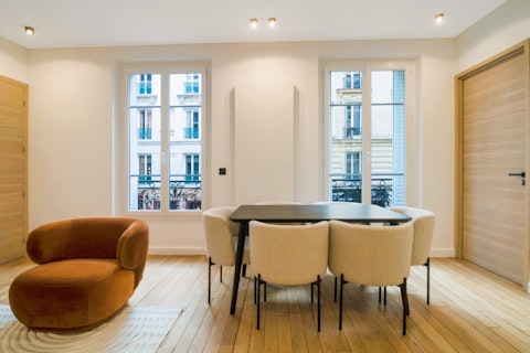 Dine beneath tall Parisian windows with classic iron balconies beyond