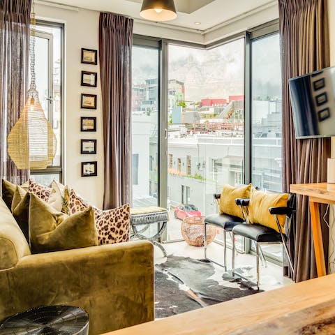 Enjoy the light streaming in through the floor-to-ceiling windows as you enjoy a glass of wine in the stylish living area