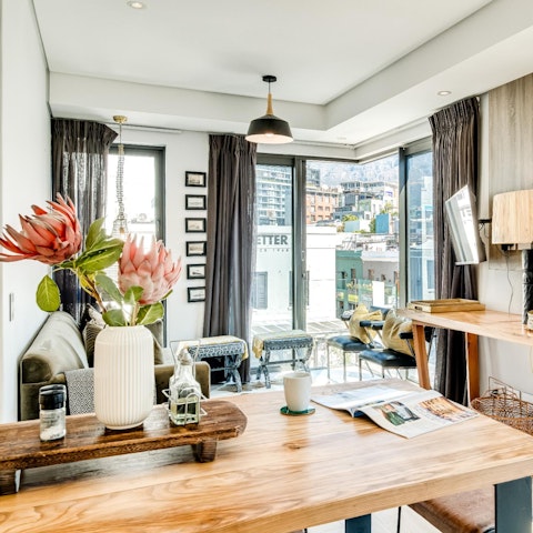 Enjoy the light streaming in through the floor-to-ceiling windows as you enjoy a glass of wine in the stylish living area