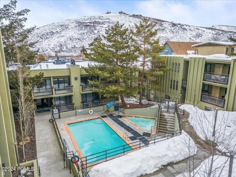 Swim in the shared pool with snow-dusted hills beyond