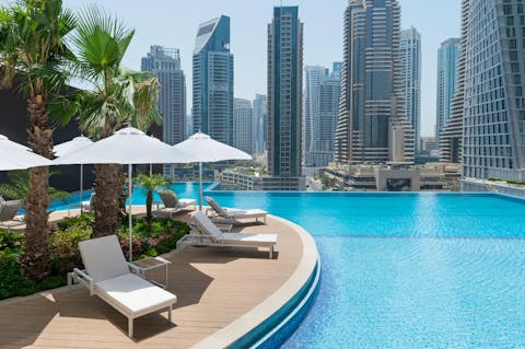 Relax by the glistening infinity pool with the unforgettable view of towering skyscrapers