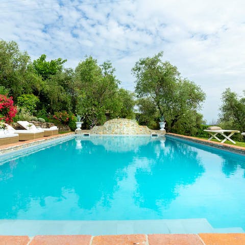 Splash about in the outdoor swimming pool surrounded by lush gardens