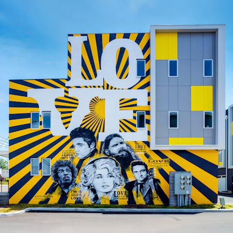 Take a photo in front of the building's huge music mural