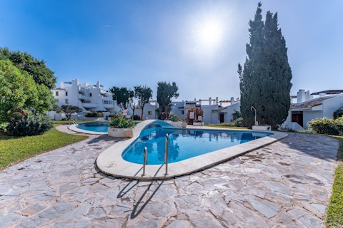 Swim in the sun-soaked communal pool set among mature landscaped gardens