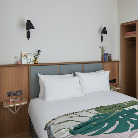 Rest easy after a long day exploring in the mid-century inspired bedroom