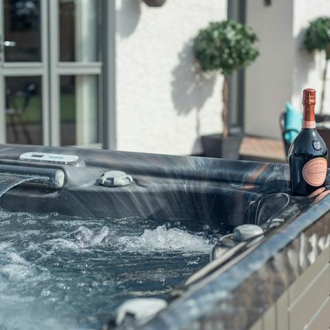 Unwind in the hot tub with the bottle of prosecco from your welcome basket
