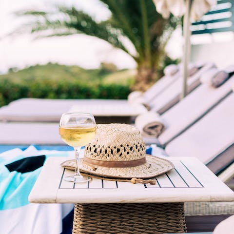 Grab a glass of wine whilst relaxing on the sunbeds