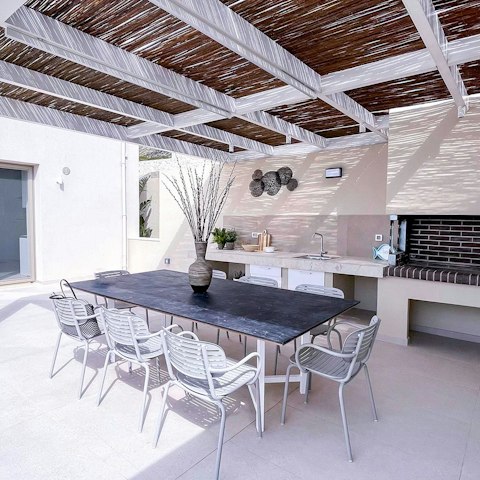 Dine under the pergola as the Cretan sky turns gold at sunset