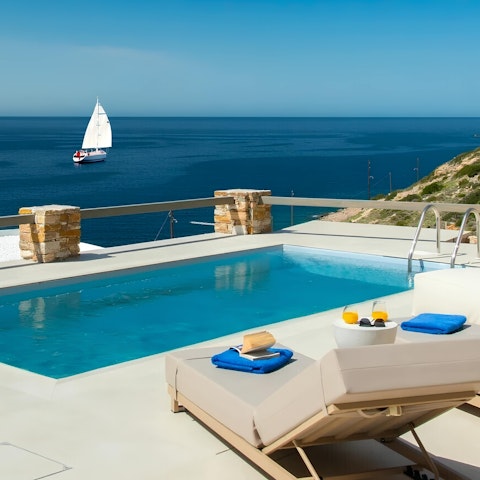Lounge by the pool and admire the spectacular Aegean views