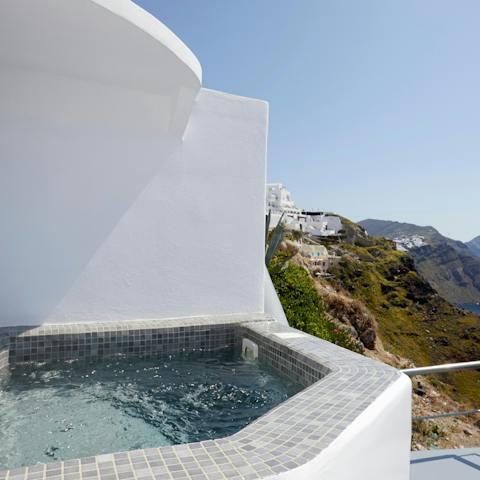 Soak up the Santorini sun from the hot tub with a glass of bubbly