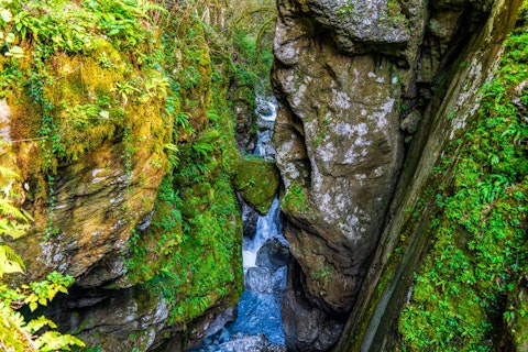 Descend into Bellano's dramatic river gorge carved through ancient rock, a two-minute walk