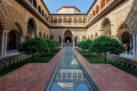 Explore the Real Alcázar's breathtaking Mudéjar palaces and royal gardens, a twenty-minute walk