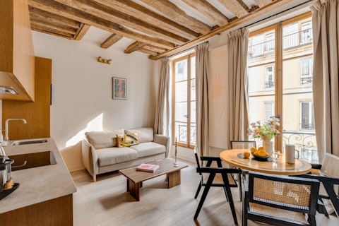 Relax beneath original timber beams in warm Parisian light