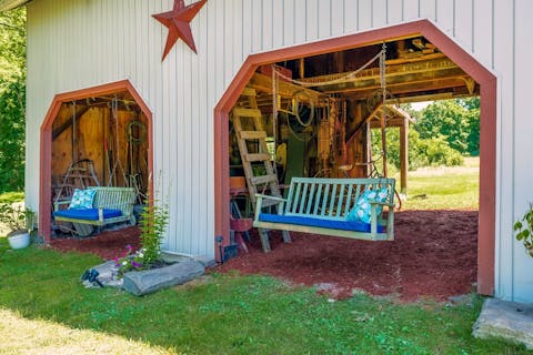 Spend afternoons on the bench swing in the converted barn 