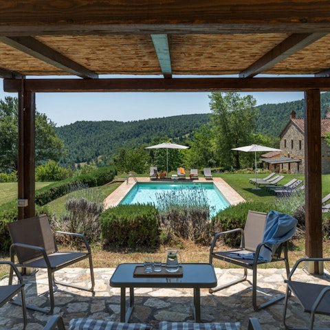 Seek shade under the pergola, with a view of the hills