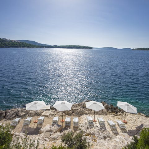 Enjoy direct access to a rocky beach, with parasols and umbrellas for you to enjoy