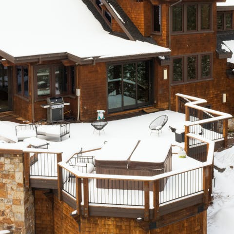 Sink into the outdoor hot tub as the snow settles around you