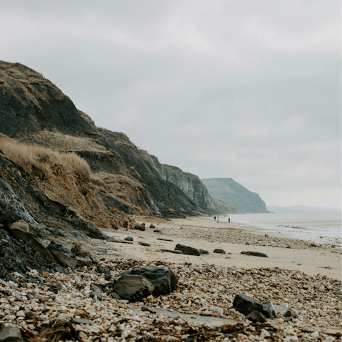 Walk along the sand in Charmouth, just three miles away