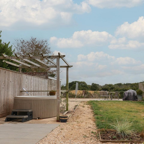 Take in the views over the meadows from the hot tub
