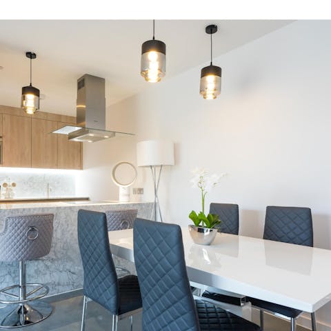 Dine altogether around the gleaming white table in the open-plan living space