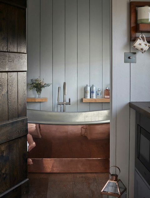 Step into a handsome copper bathtub stocked with L'Occitane toiletries
