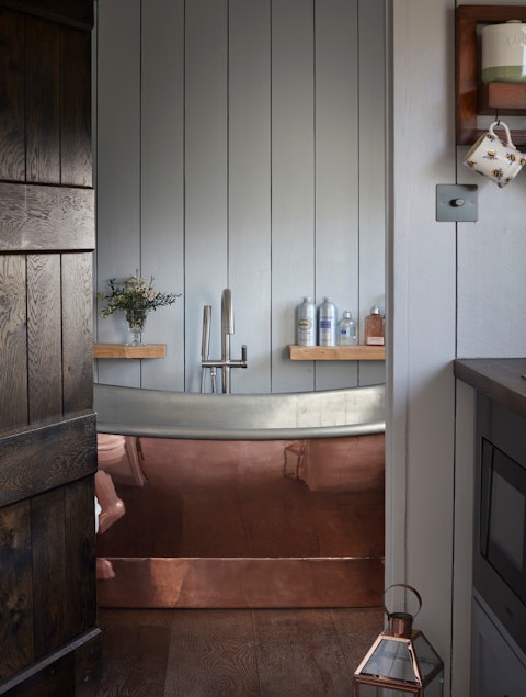 Step into a handsome copper bathtub stocked with L'Occitane toiletries