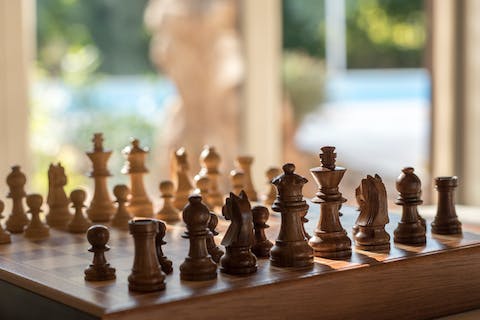 Go tech-free and teach your kids how to play chess, while you escape the midday sun