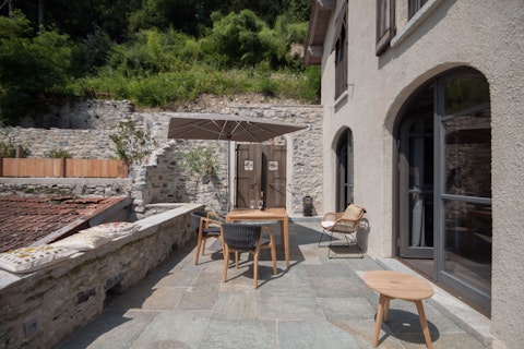 Dine alfresco surrounded by ancient stone walls and hillside greenery