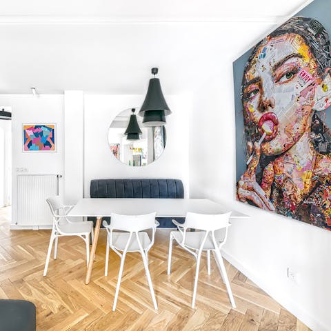 Plan the day's itinerary at the dining table surrounded by bold artworks