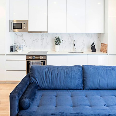 Rest weary feet on the blue velvet sofa before making dinner in the sleek kitchen