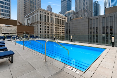 Swim laps in the communal pool, with the city skyline rising all around you