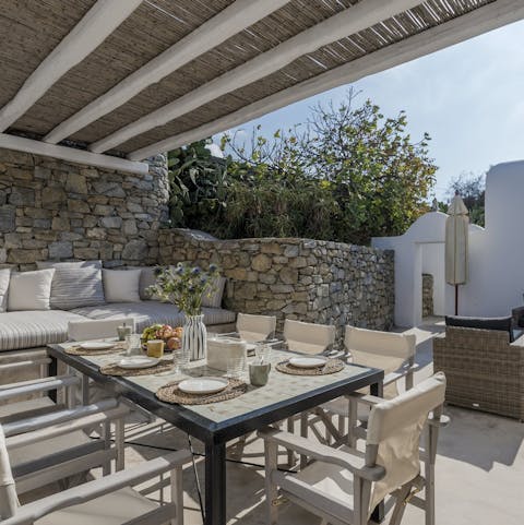 Dine alfresco under the thatched pergola