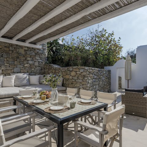 Dine alfresco under the thatched pergola
