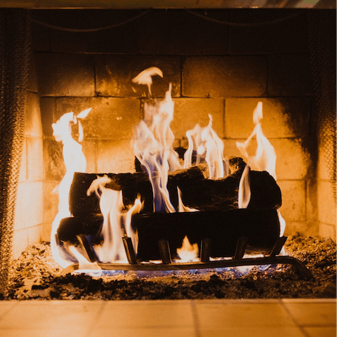 Warm up by the log-burning fireplace in the living area