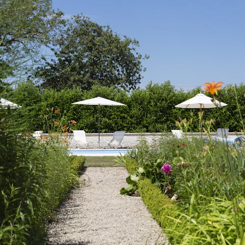 Stroll through the beautifully curated flowerbeds to reach the private pool
