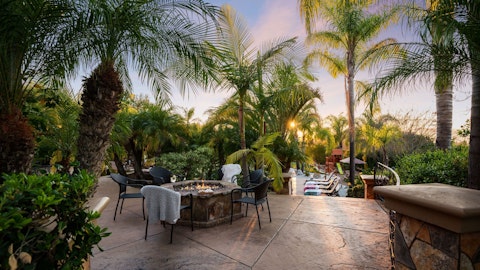 Gather around the fire pit as the sun drops below the palms