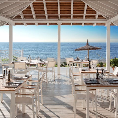 Enjoy cocktails at The Beach Club with a view of crashing waves and golden sand