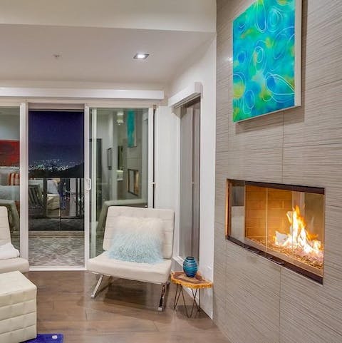 Get cosy by the fireplace, with the twinkling city skyline just behind you
