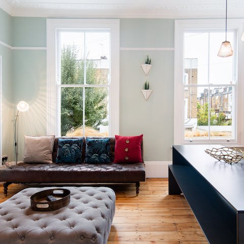 Throw yourself on the leather sofa and relax underneath the tall windows