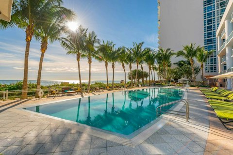 Cool off in the shared pool as the ocean glitters beyond