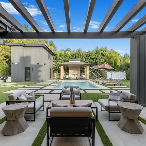 Clink drinks under the sun as the kids play in the heated pool