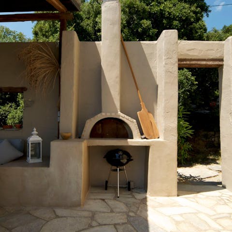 Cook fresh pizzas topped with herbs from the garden in the stone-baking oven