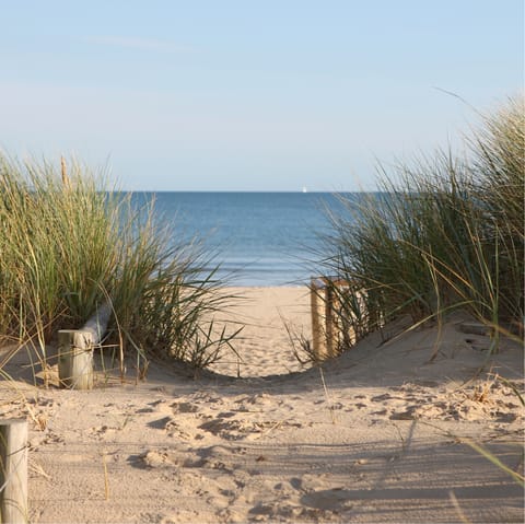Take a seventeen-minute drive to the sandy shores of Tywyn Beach
