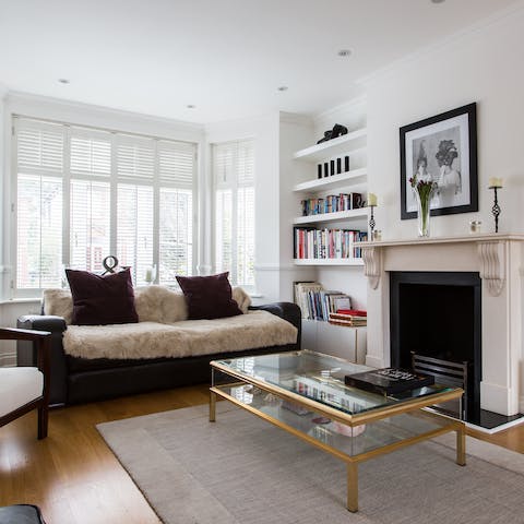 Pick a book off the shelf and cosy up on the sofa by the ornate fireplace
