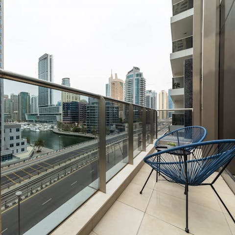 Watch the sun fall beneath the skyscrapers from your private balcony