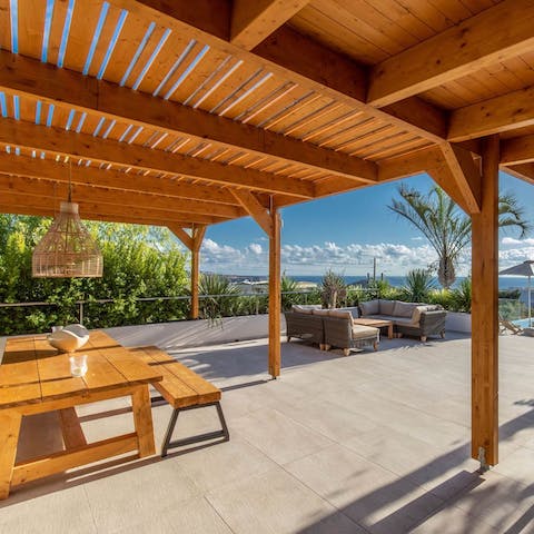 Dine alfresco as you drink in the view of the Aegean Sea